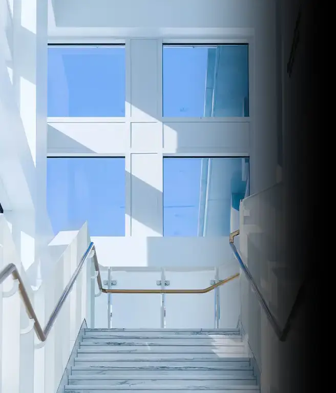 Casa com paredes brancas e janelas com as películas LoView que se adaptam automaticamente de um tom mais claro para um tom mais escuro quando expostos à luz solar