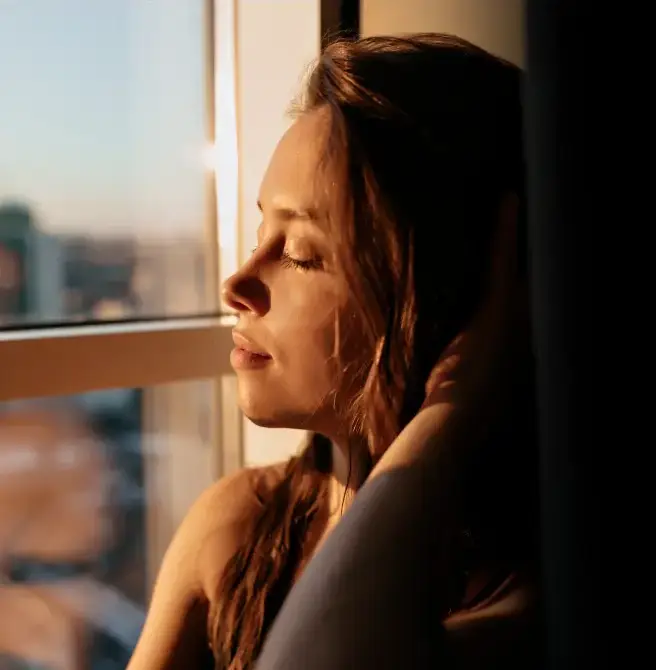 Mulher em uma janela com película Innova que bloqueia cerca de 53% de energia da luz