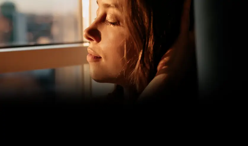 Mulher em uma janela com película Innova que bloqueia cerca de 53% de energia da luz